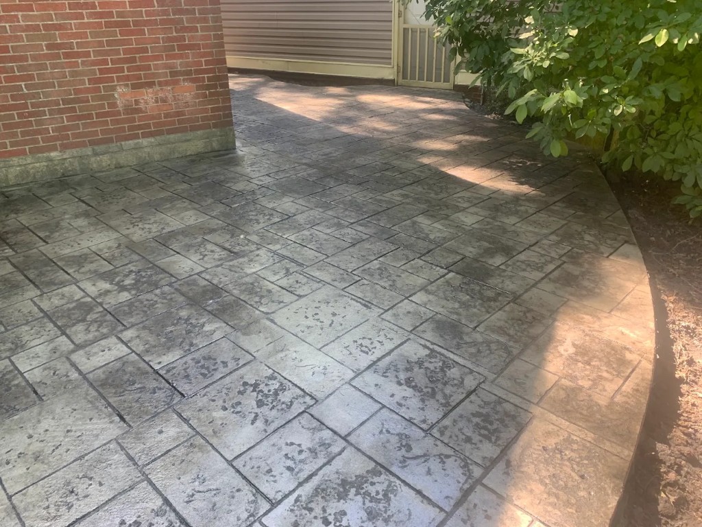 Stamped ashlar concrete patio with a curved border