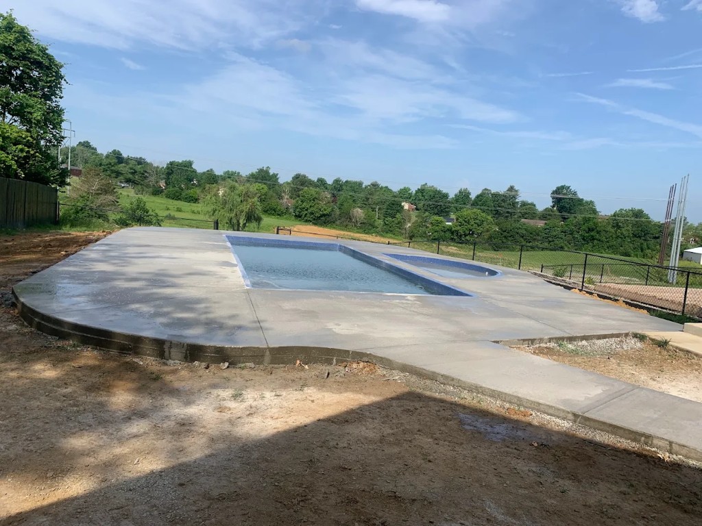 Finished concrete deck surrounding a pool on a hillside