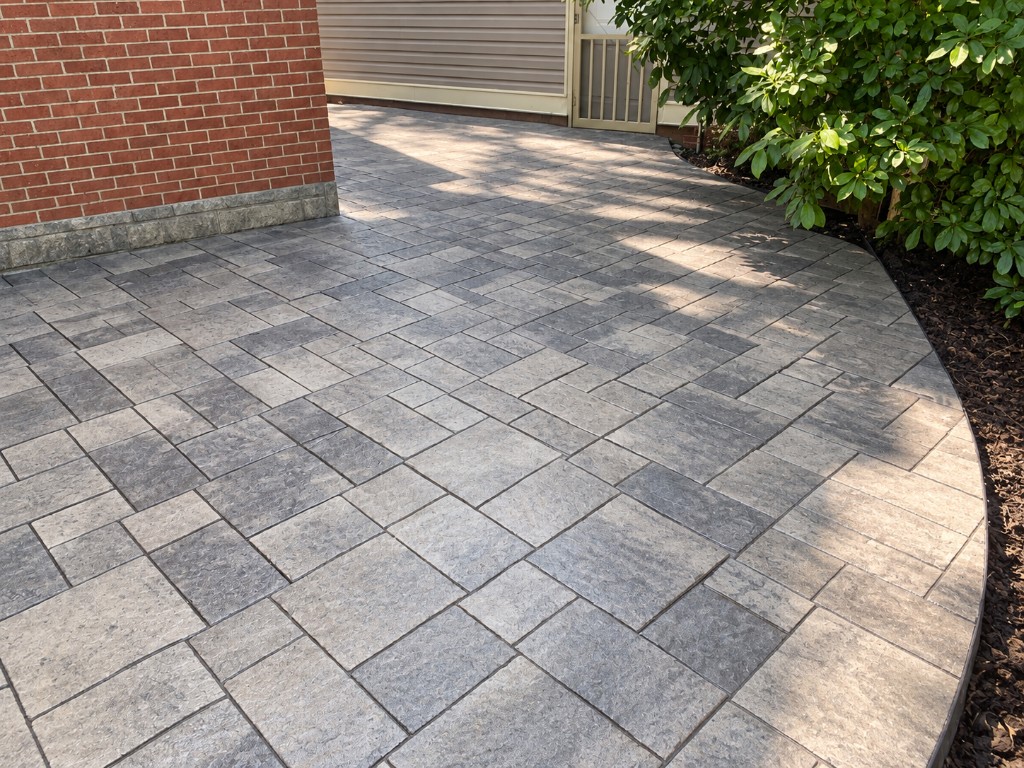 Stamped ashlar patio curving along a brick house
