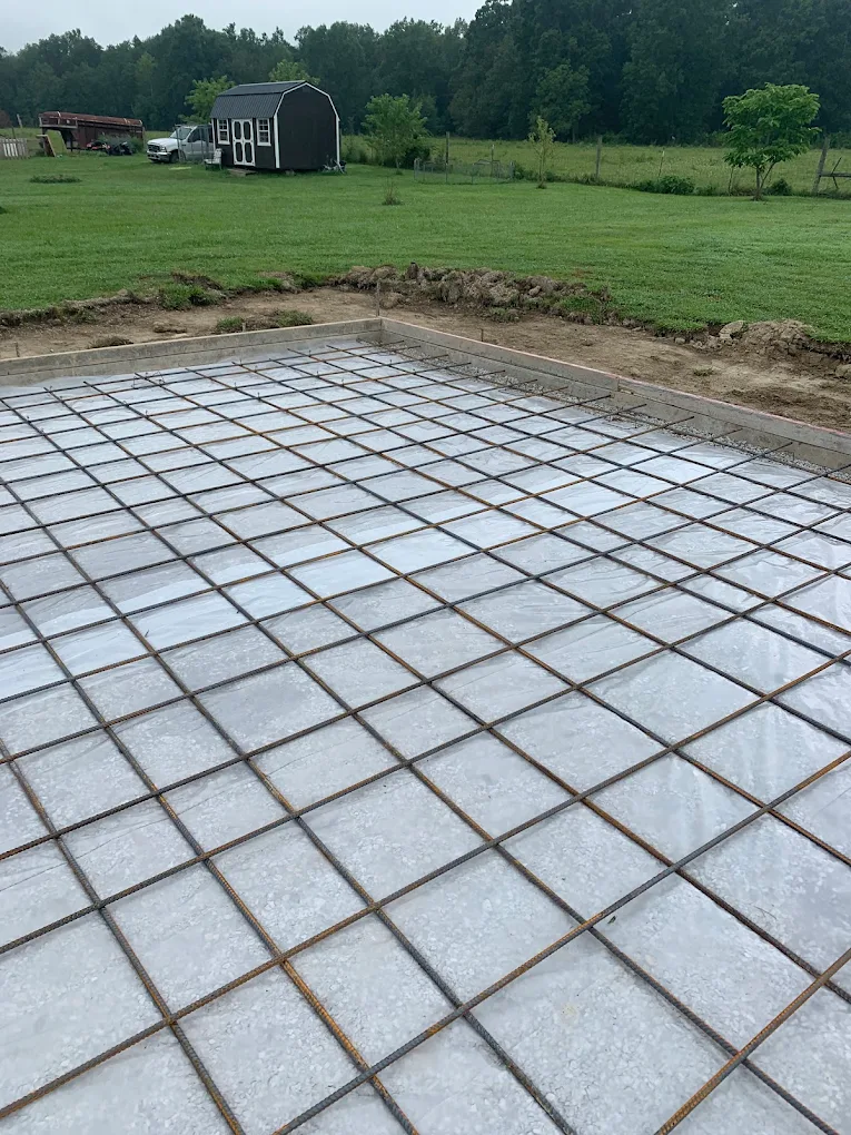 Rebar grid on vapor barrier inside forms in an open field