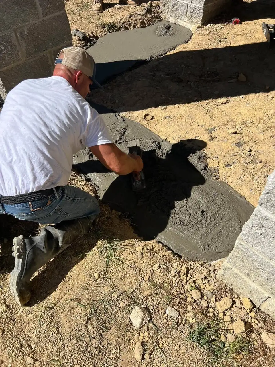 Joshua Wagers personally hand troweling wet concrete pour
